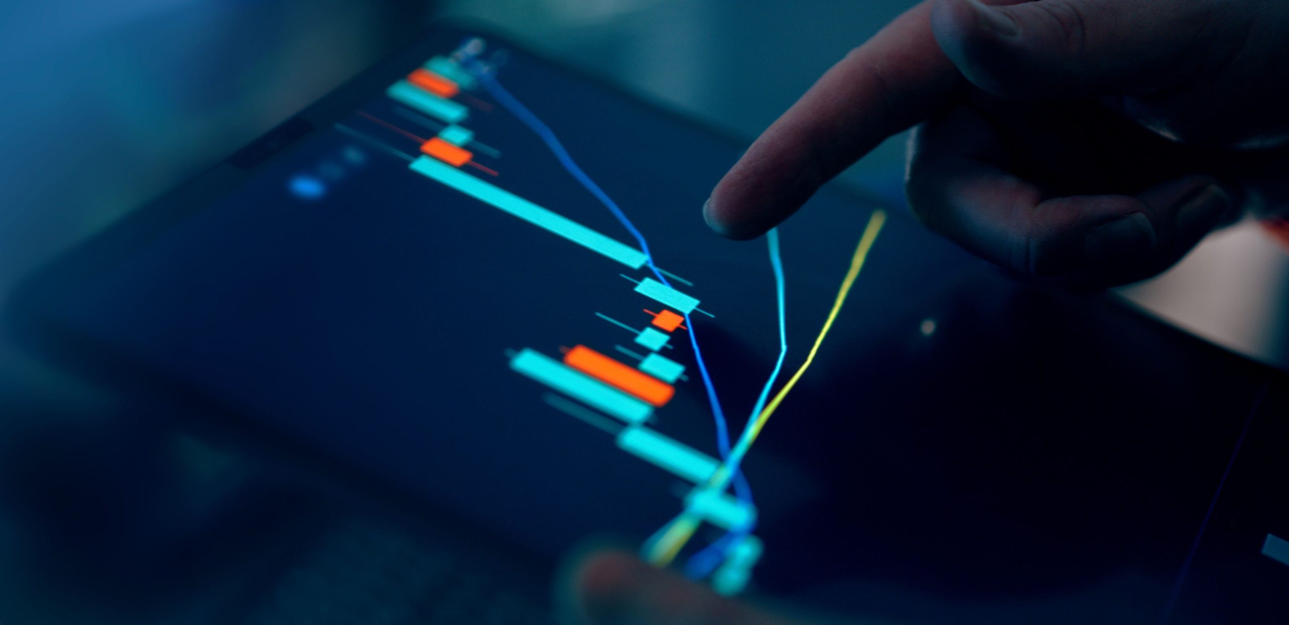 Finger pointing at a tablet depicting an upward trend on a graph