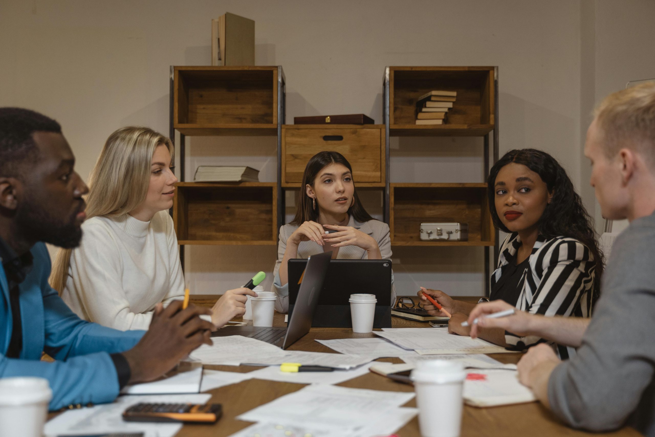 Several casual office workers sitting around a table discussing an AI maturity assessment